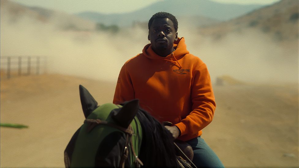 Daniel Kaluuya rider i sporrsträck från faran i Nope. Foto: Universal Pictures.