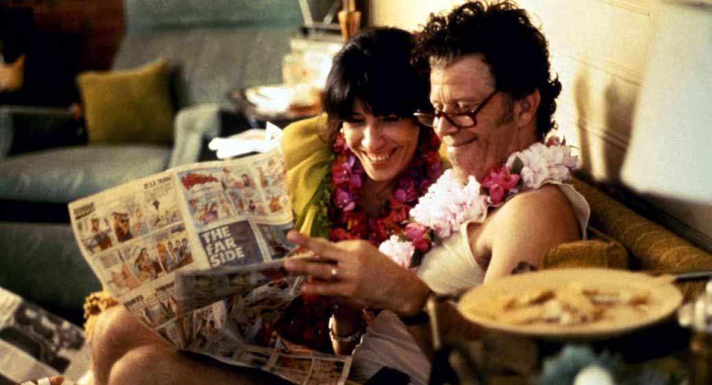Ett par sitter i en soffa och kollar tidningen i Short Cuts av Robert Altman.