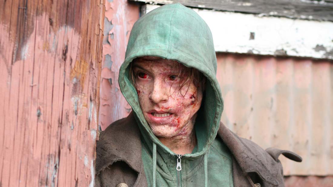 Ur Frankenstein. Monstret har huvtröja på sig och gömmer sig bakom en huskrök.