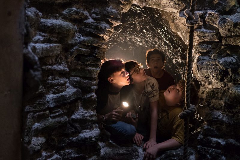 Från skräckthrillern "Det". Fyra barn tittar upp i genom ett grotthål.