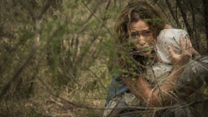 En kvinna håller om ett barnknyte i "Killing Ground"