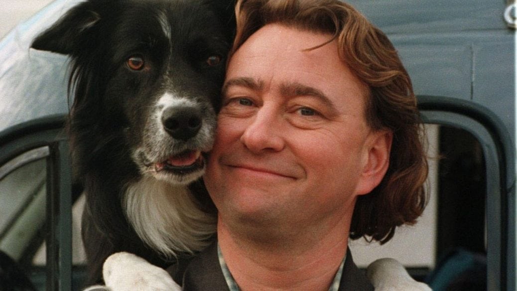Från kriminalserien "Snoken". En man och en hund ler in i kameran.