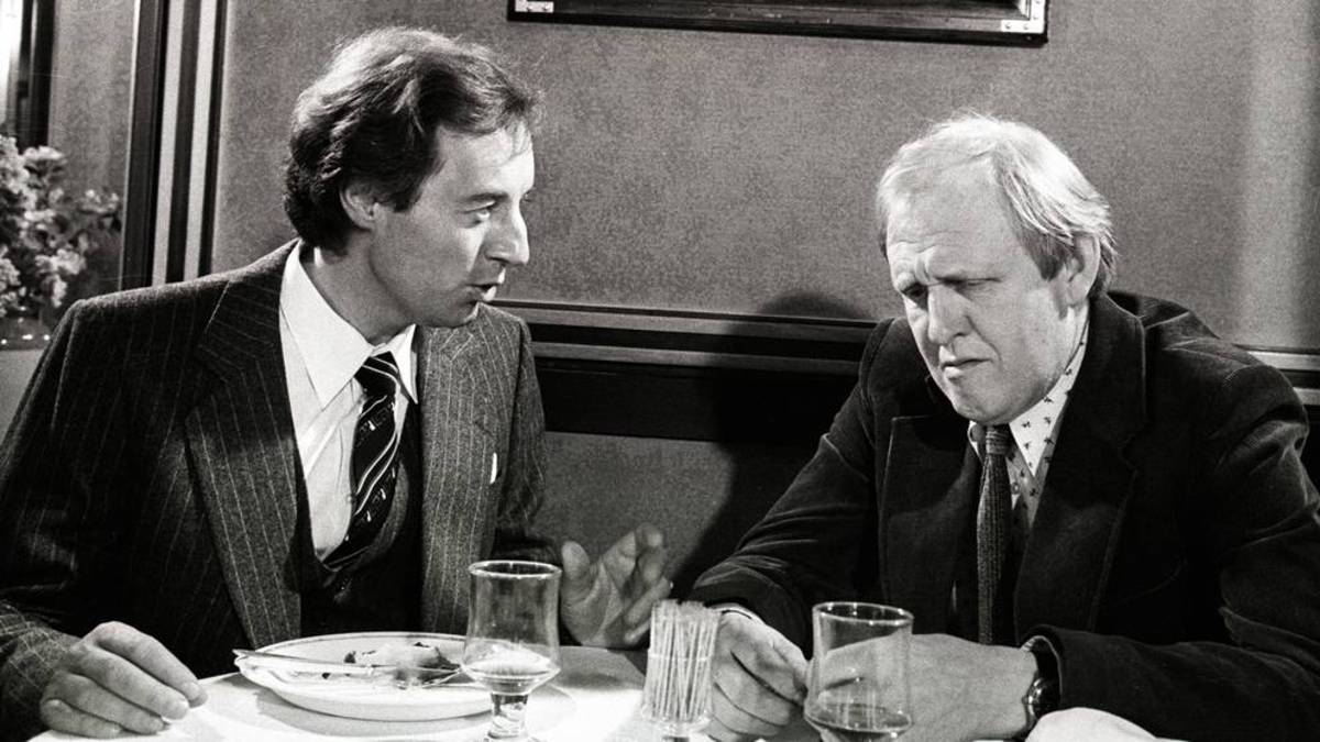 Från kriminalserien Dubbelstötarna. Två män sitter och äter lunch tillsammans.