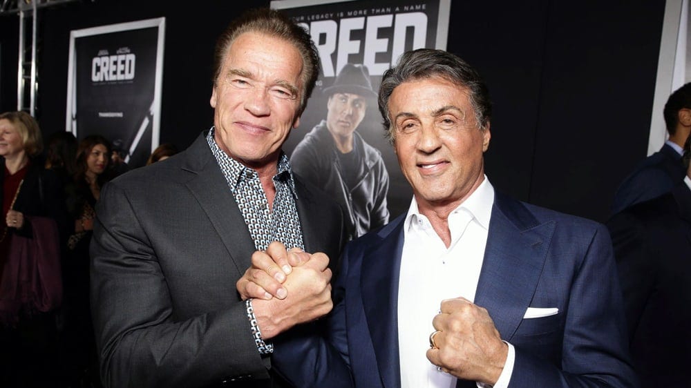 Arnold Schwarzenegger och Sylvester Stallone skakar hand på PR-event