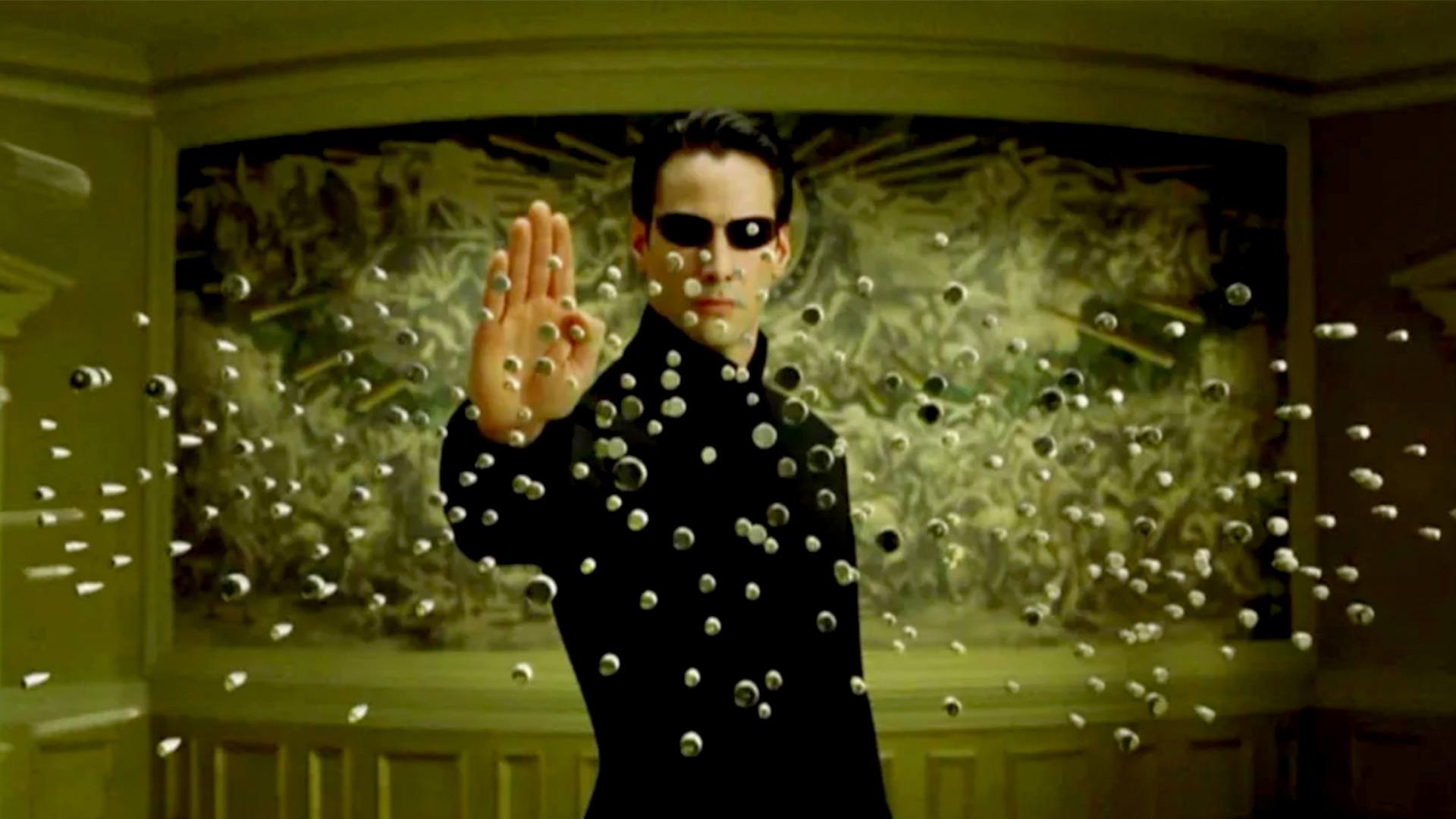 Neo kan stoppa kulor genom att hålla upp handen. Det kan tyckas slå Jesus lunchförmåga. Foto: Warner Bros. Pictures.