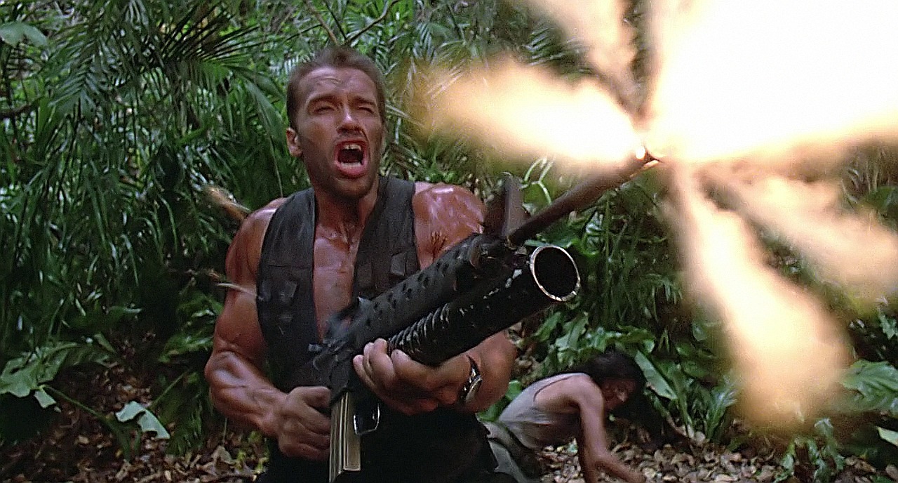 Muskler, ett maskingevär och en skrikande Arnold Schwarzenegger. Det blir inte mer 80-tal än så här. Foto: 20th Century Fox.