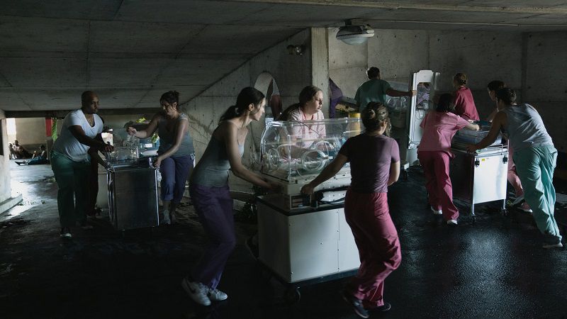 Sjuksköterskor skyndar för att evakuera för tidigt födda bebisar. Foto: Apple TV+.