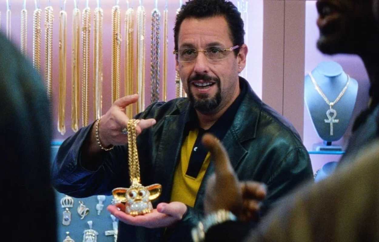 Juvelerare Howard håller i ett smycke.